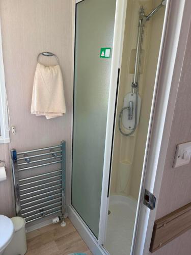a bathroom with a shower and a sink at Surf Shack Caravan - Lyons Winkups in Kinmel Bay