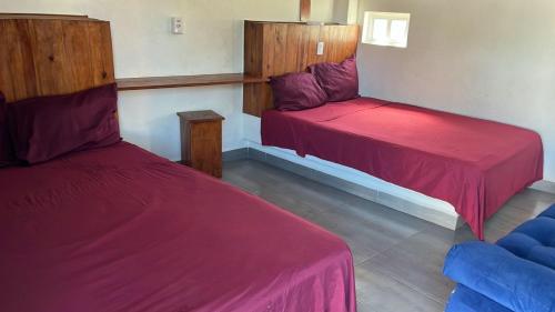 two beds in a room with red sheets at Hotel Vista Hermosa Aeropuerto Puerto Vallarta in Puerto Vallarta