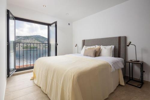 a bedroom with a large bed and a large window at Sunset Terrace Vinisce in Vinišće