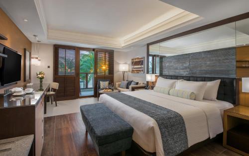 ein Schlafzimmer mit einem großen Bett und ein Wohnzimmer in der Unterkunft Henann Prime Beach Resort in Boracay