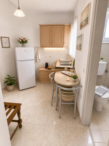 a small kitchen with a table and a refrigerator at Ιno Skiathos in Skiathos