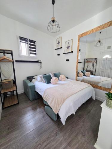 a bedroom with a large bed and a mirror at *Ça me convient* Studio Chaleureux in Villejuif