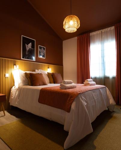 a bedroom with a large bed and a chandelier at Azorica Pico in Madalena