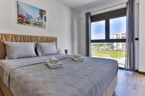 a bedroom with a large bed with two towels on it at Seaside Premium Apartments Bar - Susanj in Bar