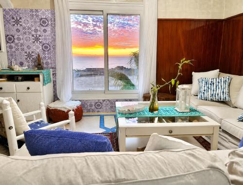 a living room with a view of the ocean at HeenaluSurfCamp - ocean view appartement - 4P - Tamraght in Tamraght Ouzdar
