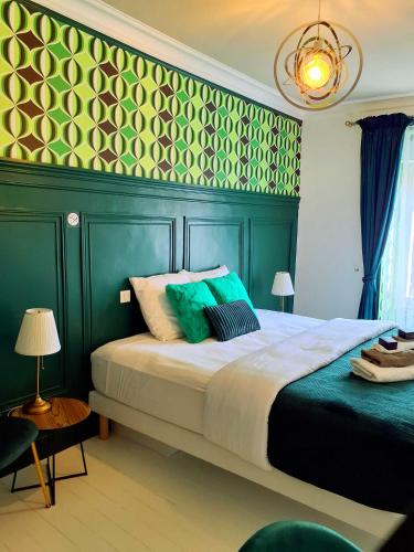 a bedroom with a large bed with a green wall at L'Insolite in Gorges