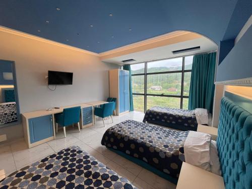 a hotel room with two beds and a window at Hotel KTHELLA in Rrëshen