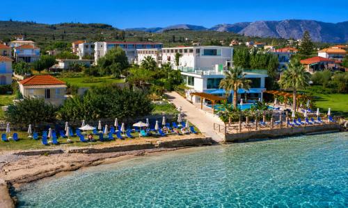 a resort with chairs and umbrellas on the beach at Belussi Beach Hotel & Suites in Kypseli
