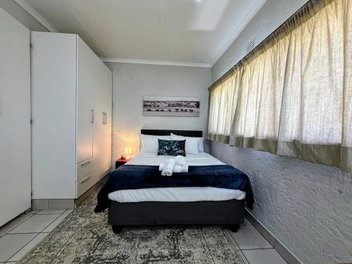 a bedroom with a bed with a teddy bear on it at Signature Suite in Kempton Park