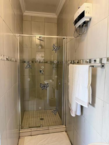 a shower with a glass door in a bathroom at Signature Suite in Kempton Park