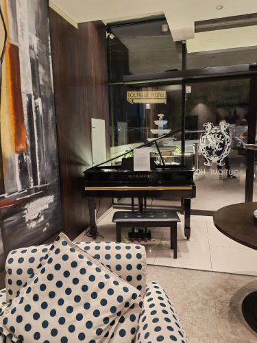a living room with a piano and a couch at Boutique Hotel in Baghdād