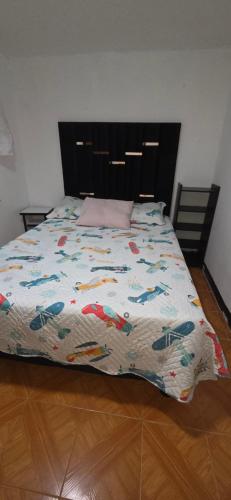 a bed with a colorful comforter on top of it at Departamento central Lg in Pereira