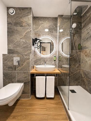 ein Badezimmer mit Waschbecken und Dusche in der Unterkunft Logis Hotel Altina in Pacy-sur-Eure