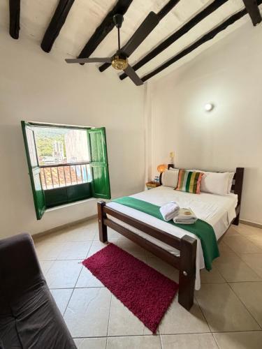 a bedroom with a bed with a red rug at Green Door San Gil in San Gil