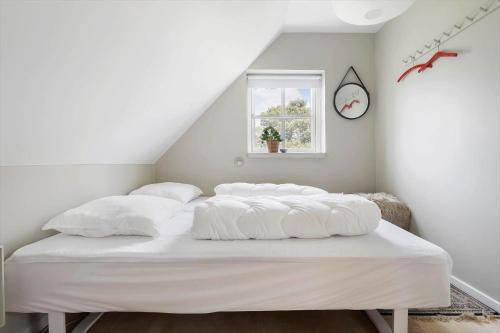 a bed with white sheets and a window in a room at 20430-Samso-Ballenvej-34A in Ballen