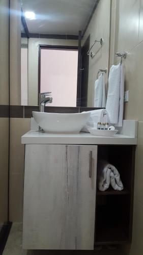 a bathroom with a sink and a mirror and towels at Rivière Boutique Hotel in Medellín