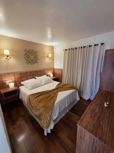 a bedroom with a large bed and wooden floors at The Winter Mountain Hotel in Monte Verde