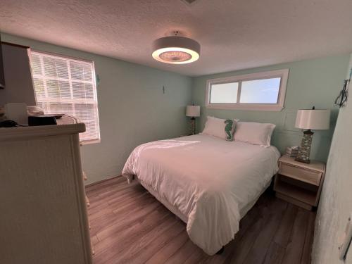 a bedroom with a white bed and two windows at Paradise Found-Key Largo Kampground Divers Welcome in Key Largo