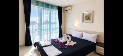 a bedroom with a bed with a large window at Afrodita Hotel in Sinemorets