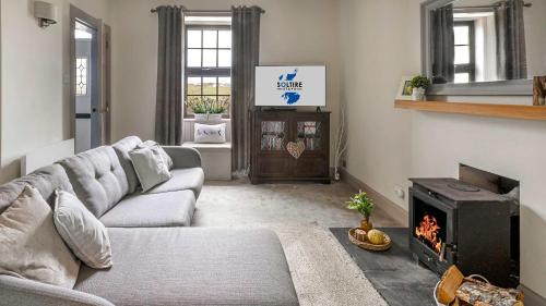 a living room with a couch and a fireplace at The Stay at Straad in Island of Bute