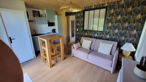 a living room with a couch and a table at le verger des Sy Pommier in Picauville