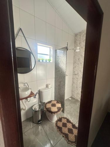 a bathroom with a shower and a toilet and a sink at Chalé do coiote 2 in São Roque de Minas