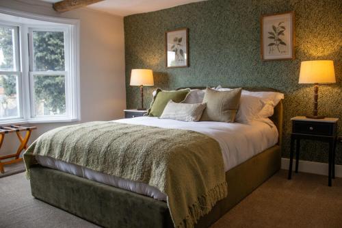 a bedroom with a large bed and two windows at The Marlborough Inn in Marlborough