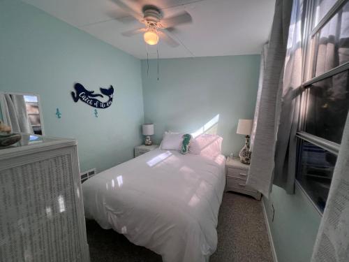 a bedroom with a white bed and a ceiling fan at Paradise Found-Key Largo Kampground Divers Welcome in Key Largo