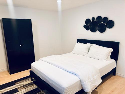 a bedroom with a bed and a black cabinet at Just Peace Homes in Moncton