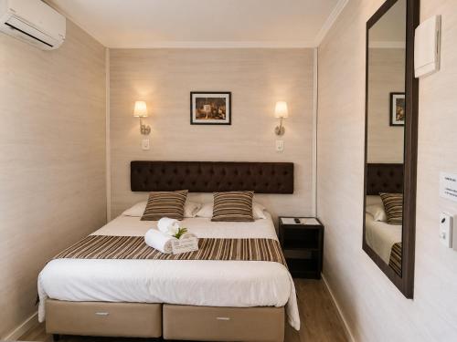 a bedroom with a large bed and a mirror at Pousada Jasmim in Gramado
