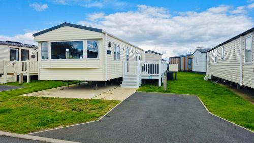a tiny house in a yard next to some houses at The Pastures 29 Caravan in Tattershall