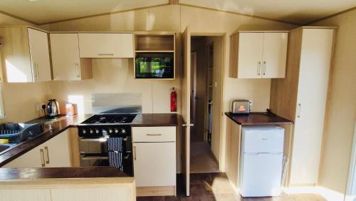 a kitchen with white cabinets and a stove top oven at The Pastures 29 Caravan in Tattershall