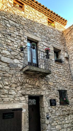 a stone building with two windows and a balcony at CAN PINÓS de GUIMERÀ in Guimerá