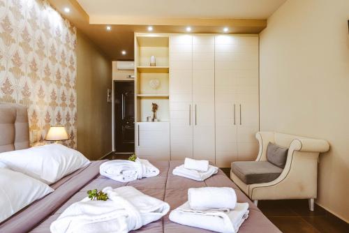 a hotel room with two beds and a chair at Ornella Beach Resort & Villas in Syvota