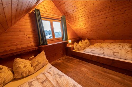 a room with two beds in a log cabin at miki Hütten in Pack