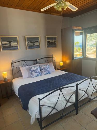 a bedroom with a bed with blue and white pillows at Polyxeni villa - Neo Klima in Skopelos Town