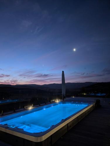 a swimming pool at night with the moon in the sky at Te Karaka Lodge in Port Waikato