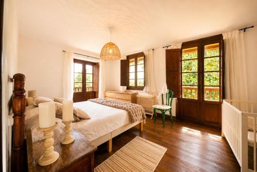 a bedroom with a bed and a desk and windows at Casa La Portilla in Labarces