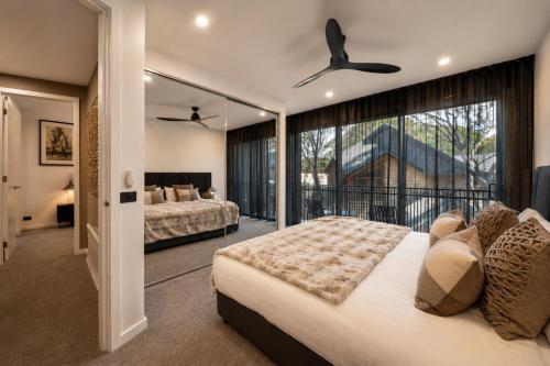 a bedroom with two beds and a balcony at Black Sheep alpine getaways in Dinner Plain
