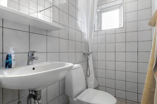 a bathroom with a sink and a toilet and a window at 20432-Samso-Klintevej-6 in Ballen