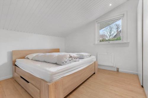 a bed in a room with a window at 84265-Ega-Strandvangsvej-27 in Skæring
