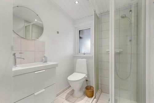a white bathroom with a toilet and a shower at 84265-Ega-Strandvangsvej-27 in Skæring