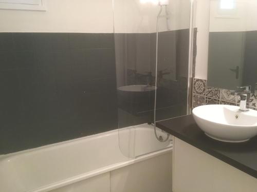 ein Badezimmer mit Waschbecken und Glasdusche in der Unterkunft APPARTEMENT 3 LITS Parking Proche Rouen Dock in Canteleu