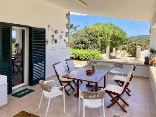 a dining table and chairs on a patio with a view at Sweet Home Spalmatore in Carloforte