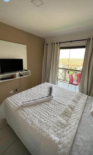 a bedroom with a large bed and a balcony at Flat Monte Castelo Gravatá - Pe in Gravatá