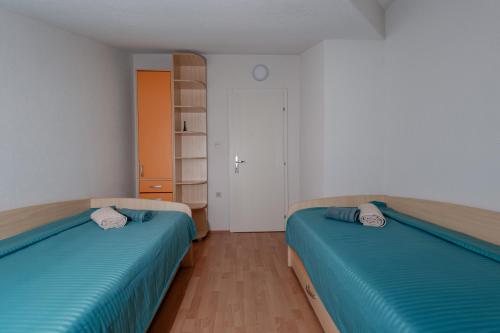 two beds in a room with blue sheets at Villa Aurora in Ohrid