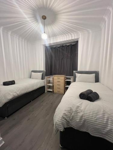 a room with two beds and a ceiling at Central Kettering Apartment by SJP Ideal for up to 3 Guests in Kettering