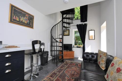 a living room with a spiral staircase and a couch at Hollins Lodge in Grosmont