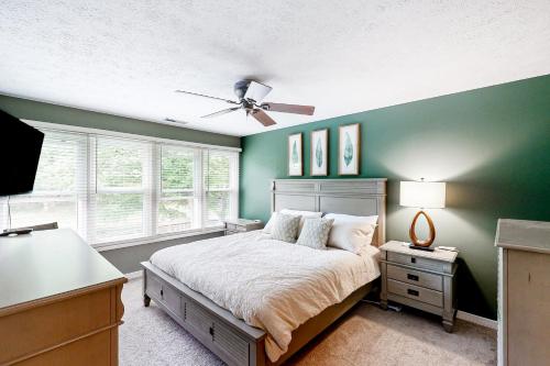 a bedroom with green walls and a bed with a ceiling fan at 'Heart Pond Resort' Home in Carmel-Westfield Area in Carmel