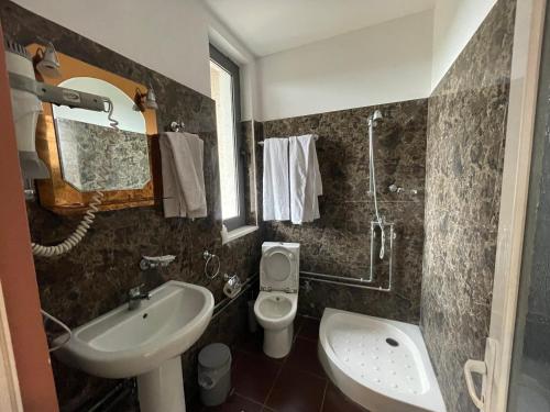 a bathroom with a sink and a toilet at Hotel KTHELLA in Rrëshen